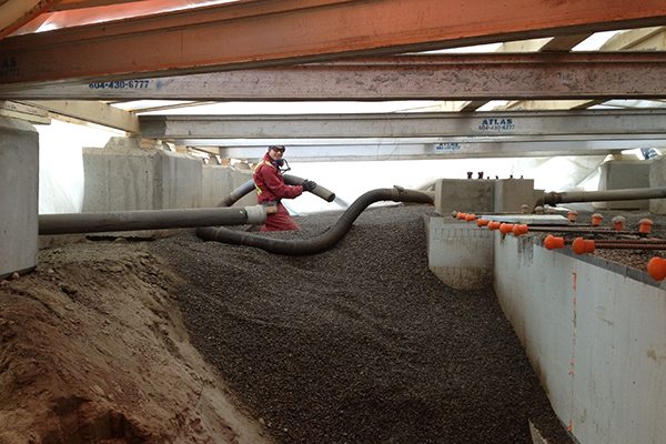 Blowing pea gravel into foundation - 100 Mile House