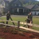 father and son spread landscaping wood chips with blower truck