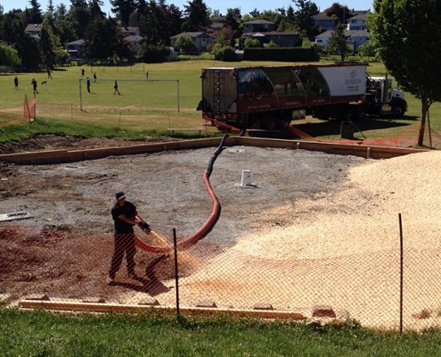 Denbow blower truck installing playground wood chips in Victoria